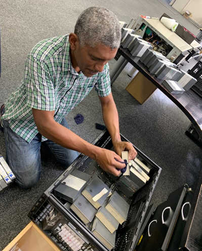 A man holding a tape, cleaning ash and dust off of it.