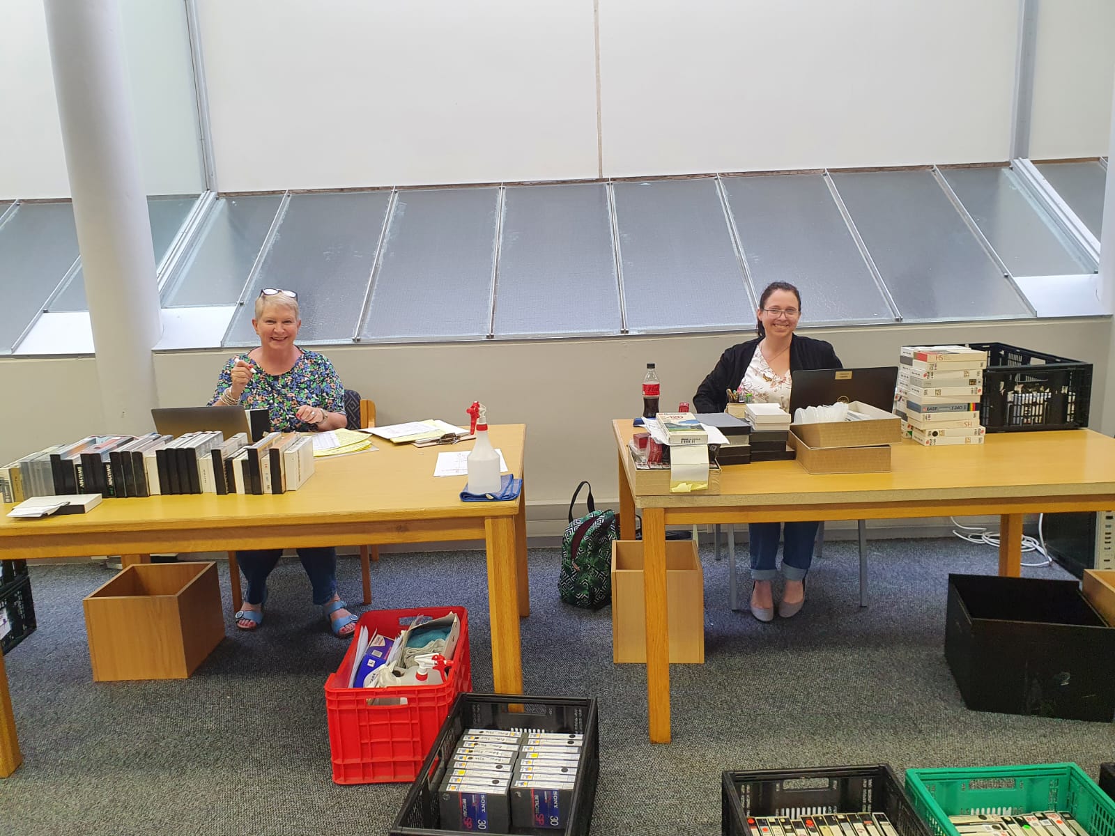 Retired African Film Librarian, Bev Angus, and Audiovisual Archivist, Andrea Walker, create metadata for material to be digitised.